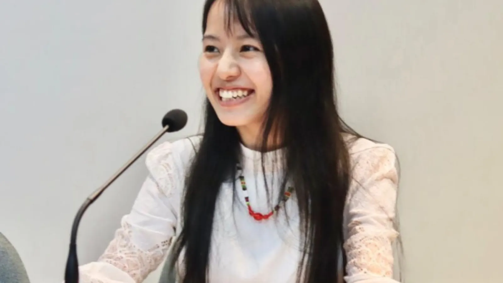 Florence Laldinpuii smiling in front of a microphone