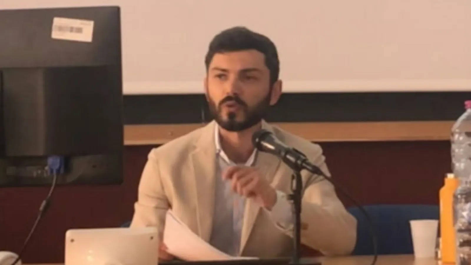 Luca Diani speaking into a microphone 