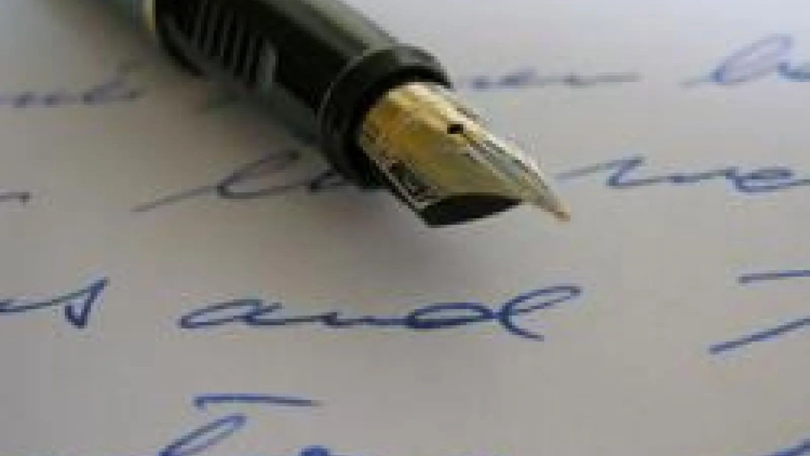 A fountain pen lies on a page of handwritten text