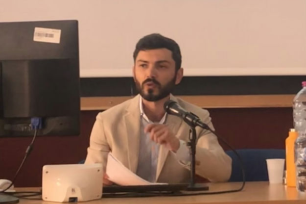 Luca Diani speaking into a microphone 